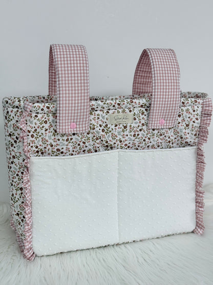 Bolso de tela floral con detalles vichy rosa colgado en carrito de bebé"