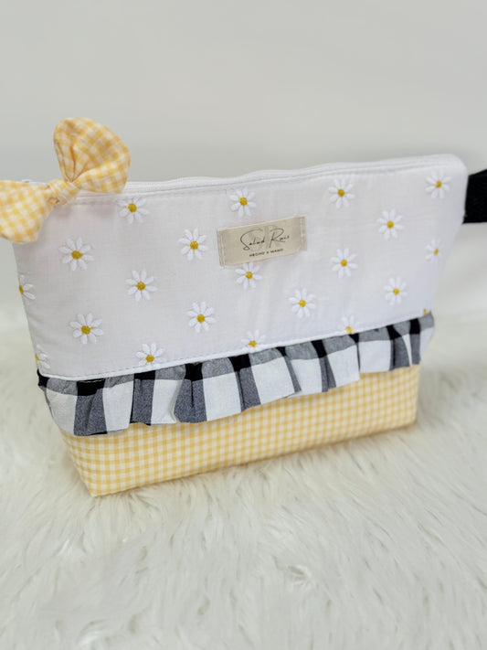 Neceser de tela artesanal de la colección margarita con volante vichy marino y lazo en la cremallera se puede usar como cartera de mano.